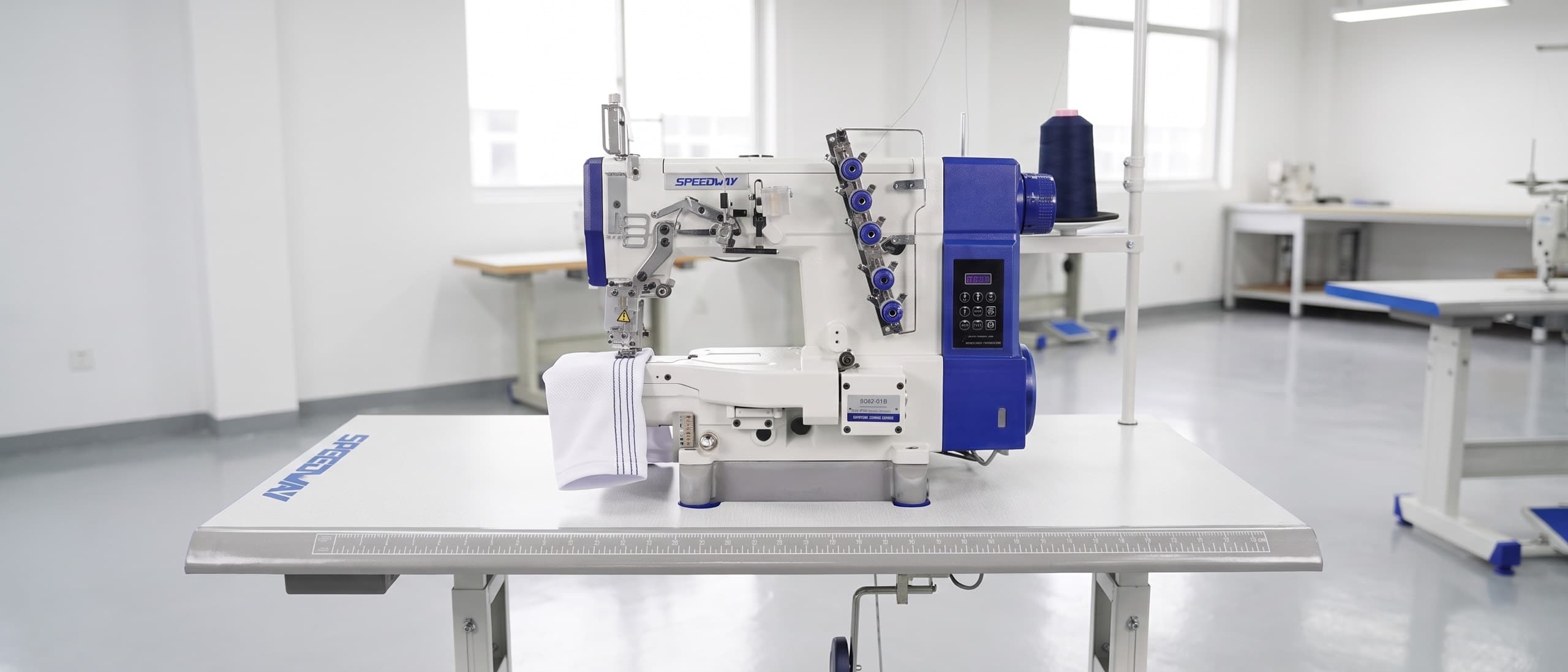 SPEEDWAY SW 662-01/CB cylinder-arm coverstitch machine hemming a white knit sleeve cuff, three parallel rows visible