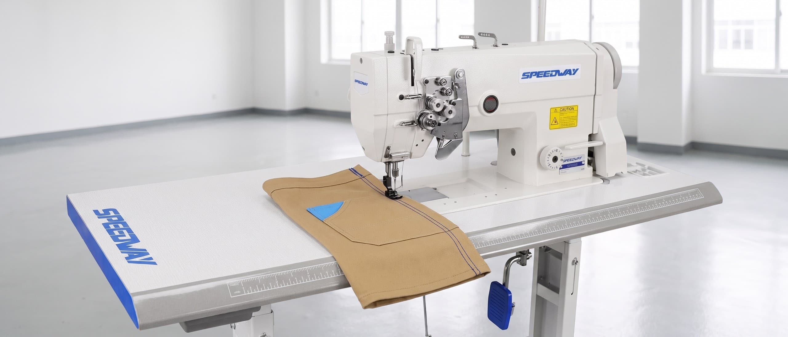 SPEEDWAY SW 845 double-needle lockstitch machine stitching two parallel navy rows on a tan canvas workwear panel